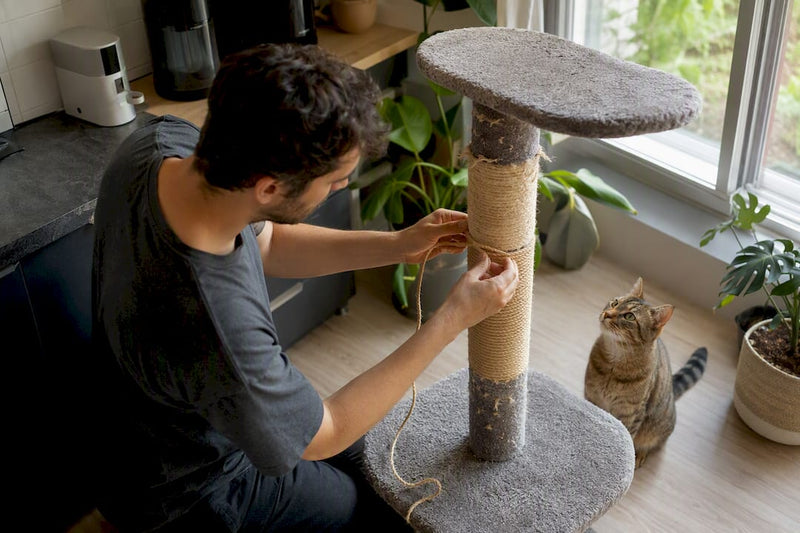 Cat owner wrapping sisal rope on scratching post