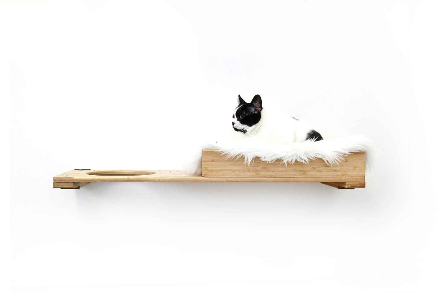 Wall-mounted bamboo cat bed with a curved front ledge and faux fur pad