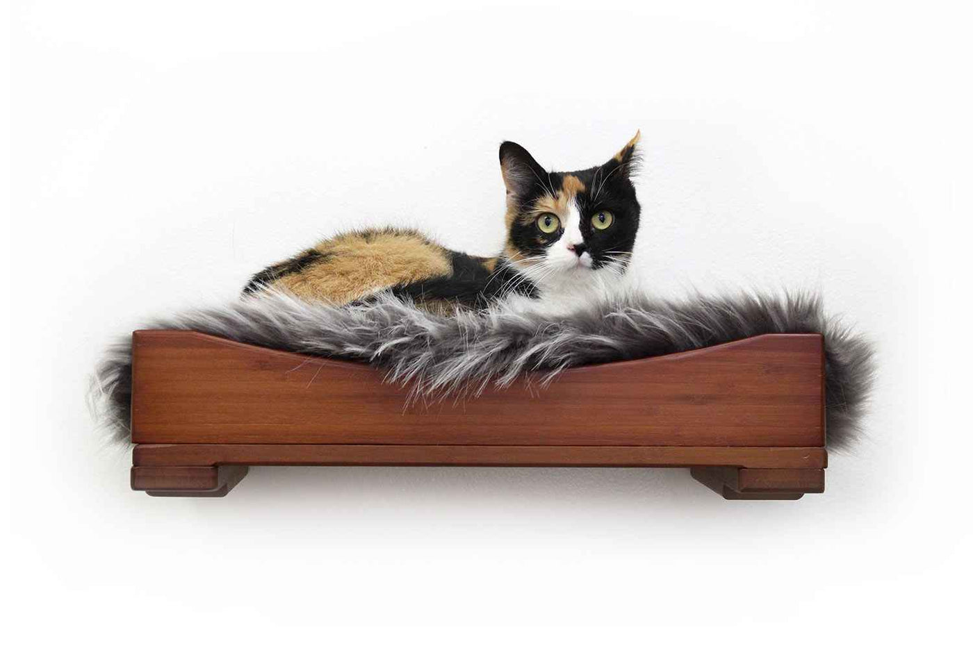Wall-mounted bamboo cat bed with a curved front ledge and faux fur pad