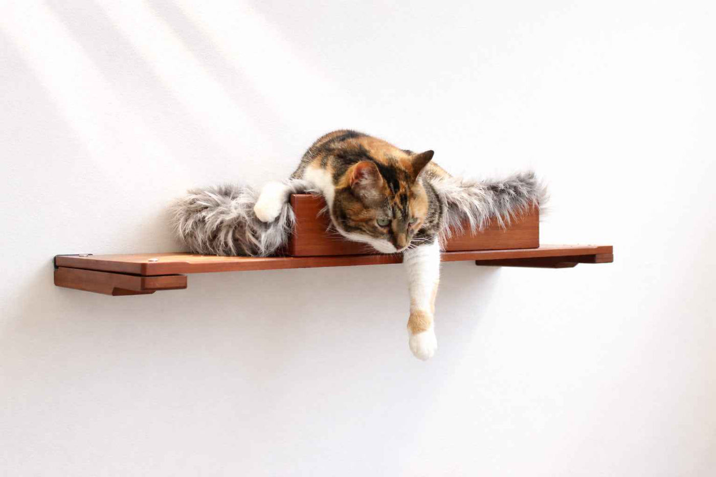 Wall-mounted bamboo cat bed with a curved front ledge and faux fur pad