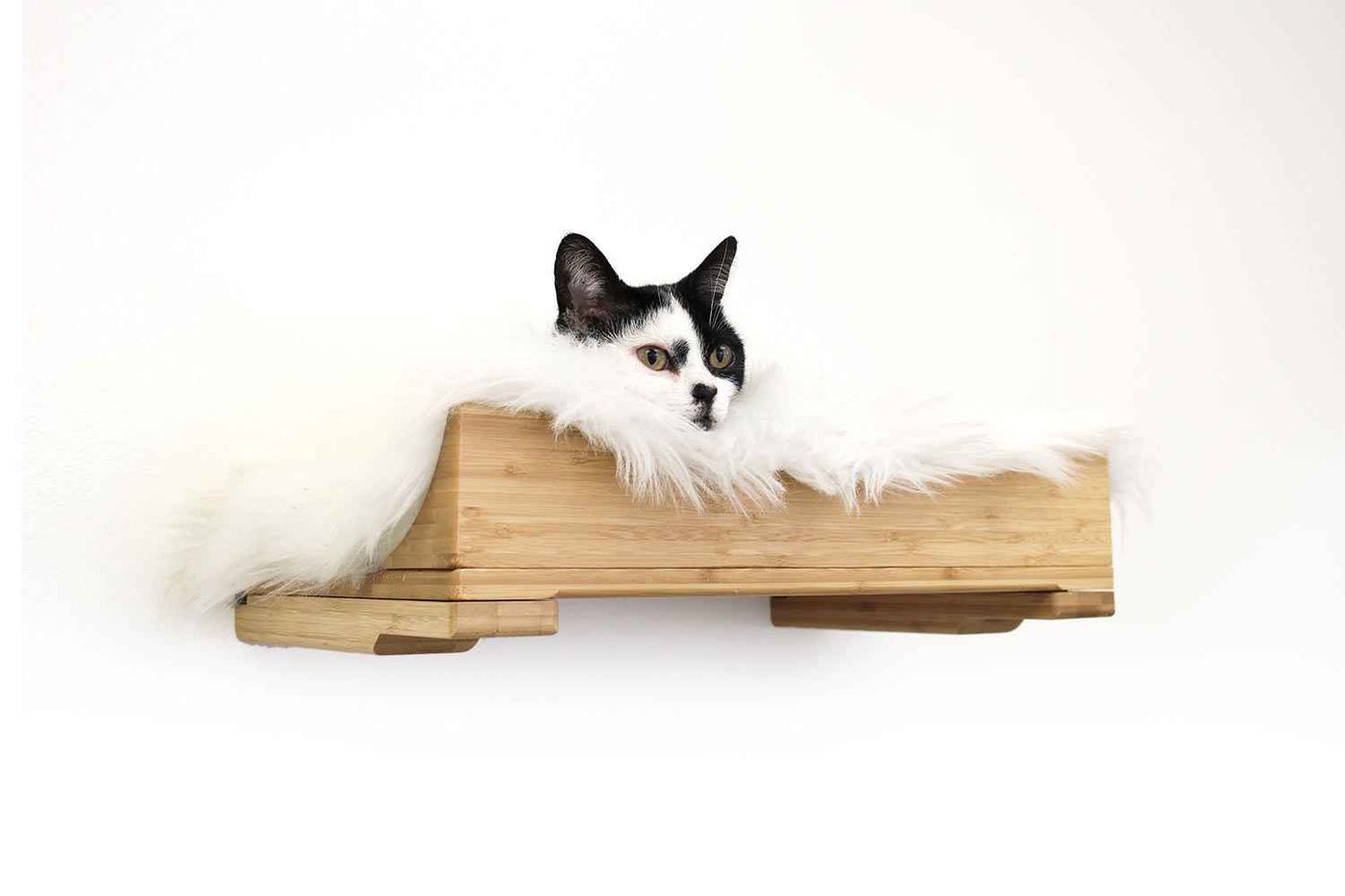 Wall-mounted bamboo cat bed with a curved front ledge and faux fur pad