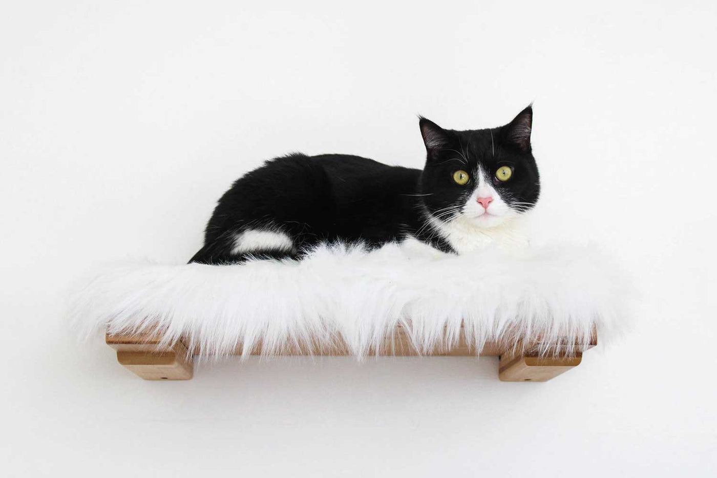 Wall-mounted bamboo cat bed with a curved front ledge and faux fur pad