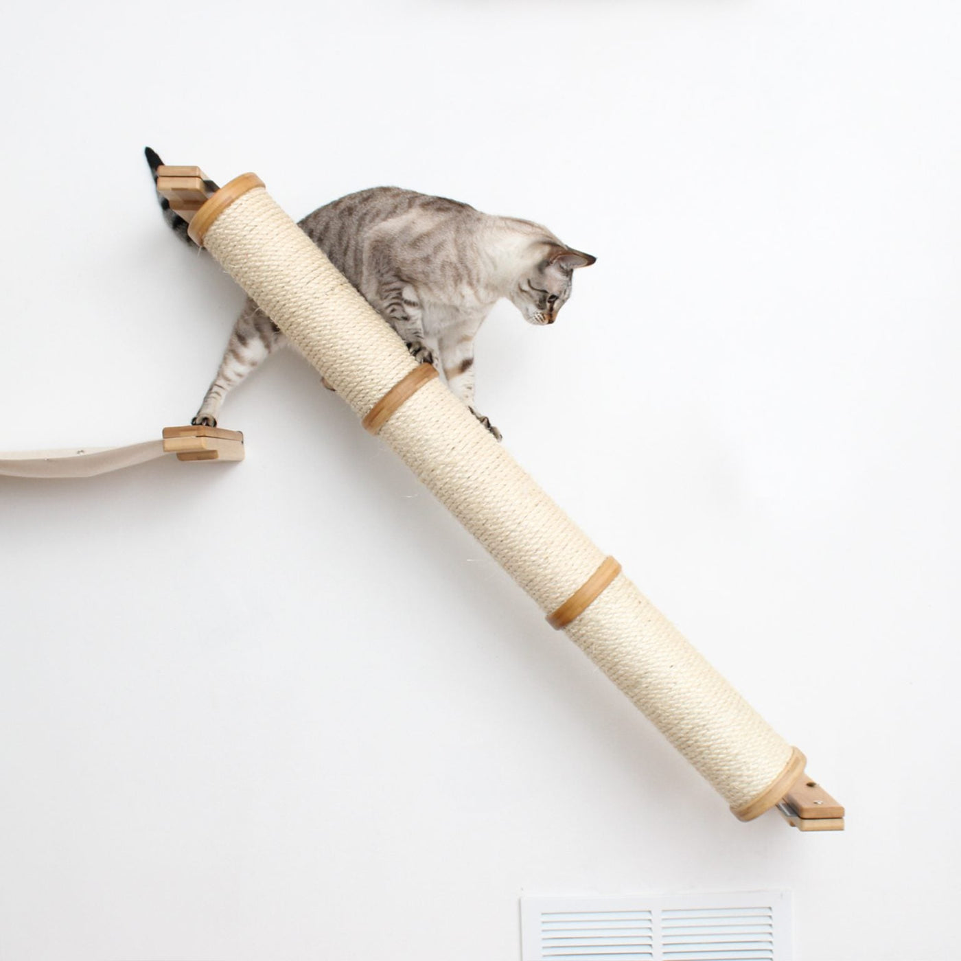 Wall mounted angled sisal cat scratcher installed on a low slope with steel mounting brackets visible