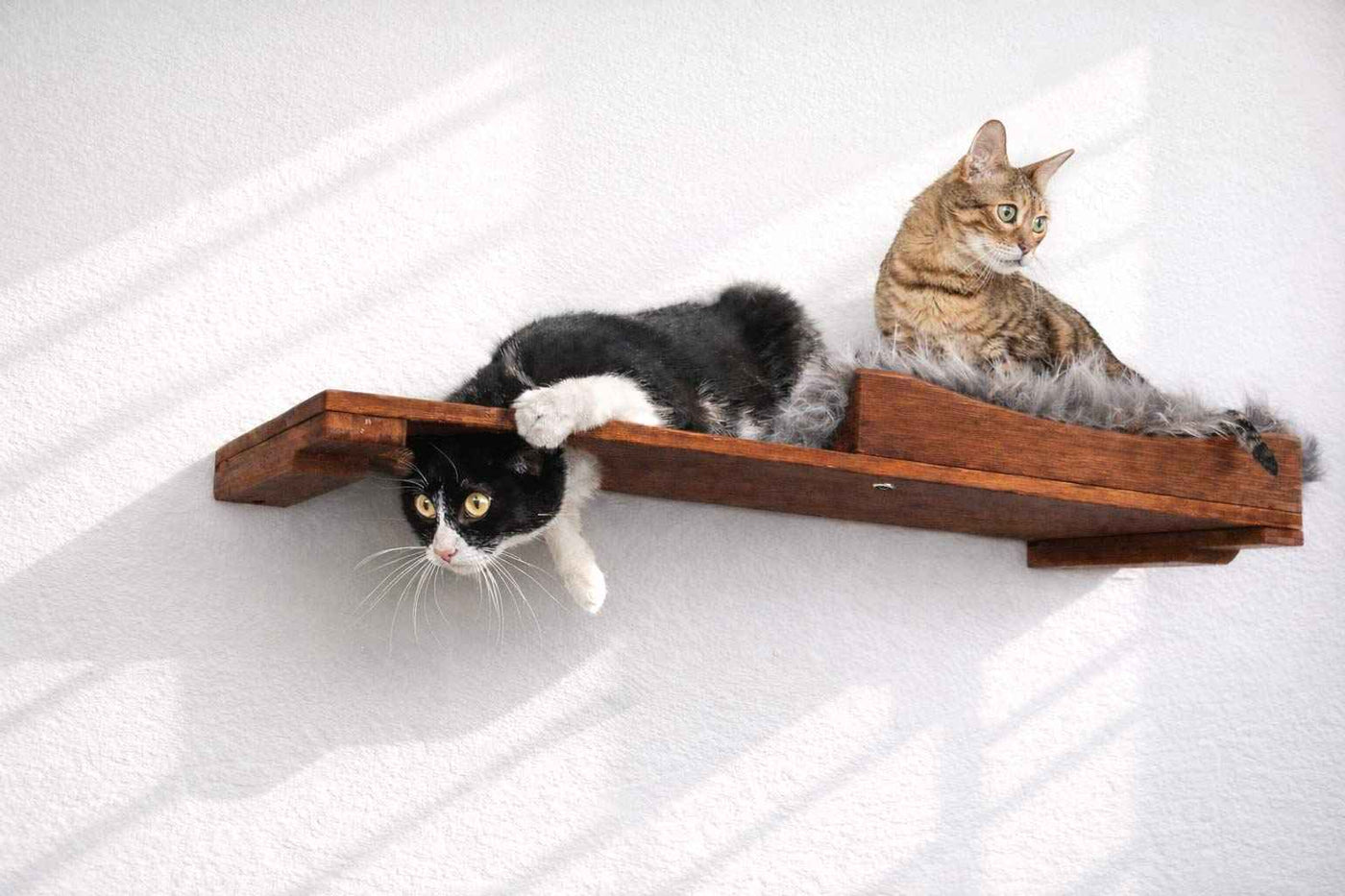 Wall-mounted bamboo cat bed with a curved front ledge and faux fur pad