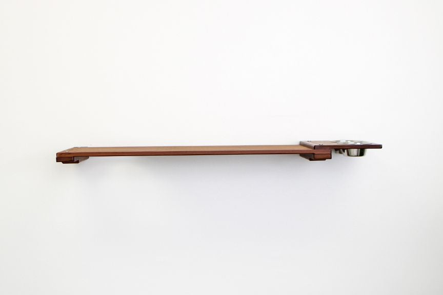 Wall mounted bamboo cat feeding shelf with two food dishes and an escape hatch opening above